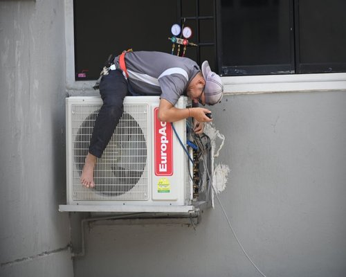 technician cleaning a wall mounted air conditioner in Cairo